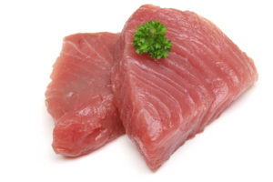 Raw tuna steaks on white background.