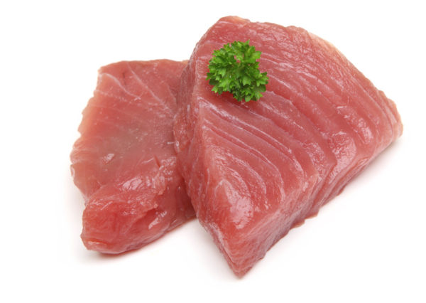 Raw tuna steaks on white background.