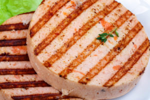 Grilled fishcake for fishburger with salad leaves